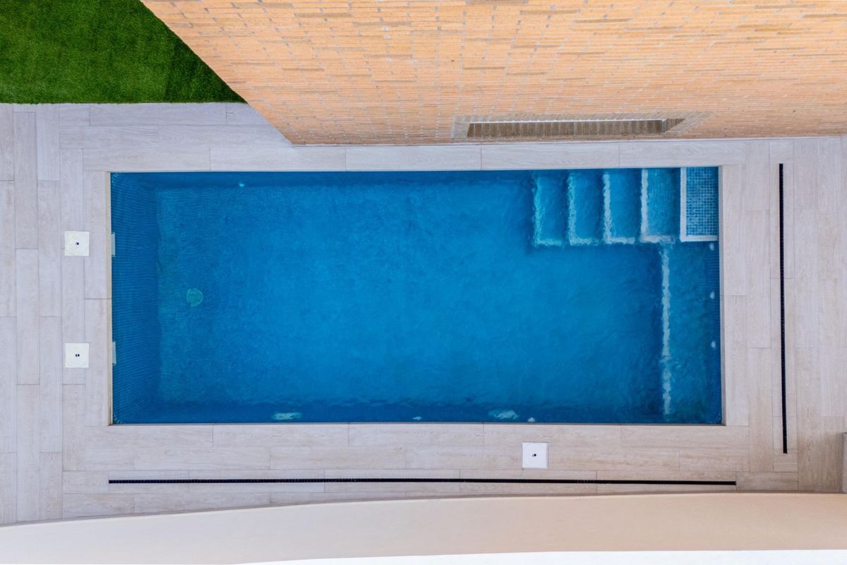 Bovenaanzicht van het zwembad bij de 4-slaapkamer villa in Rojales, met het ontwerp en de omringende gebieden.