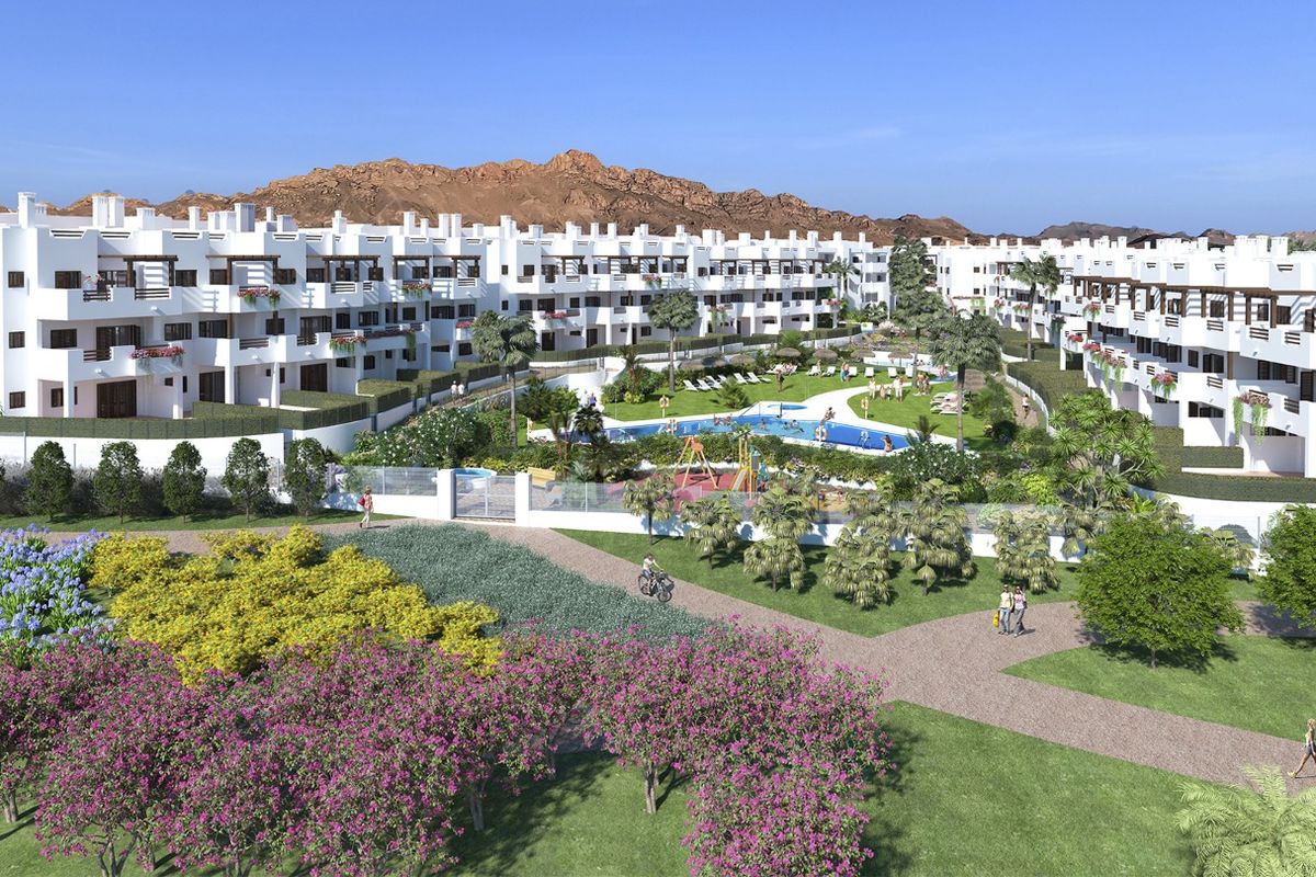 Residentieel complex met witte gebouwen, zwembad en weelderige beplanting tegen rotsachtige bergachtergrond in Mar de Pulpi