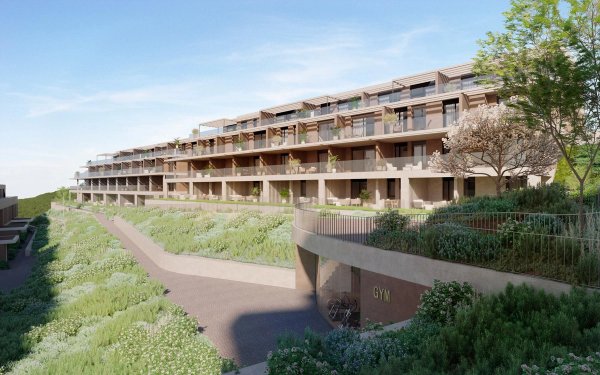 Buitenzicht op een modern 2-slaapkamer appartementengebouw in Estepona, Costa del Sol, omringd door groen.