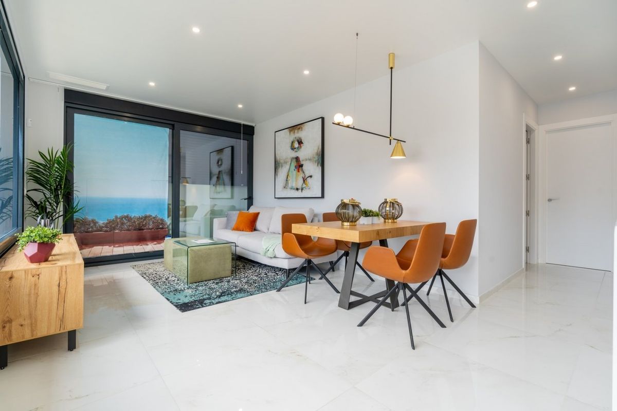 Ruime woonkamer met grote ramen en uitzicht op de stad vanuit het appartement in Benidorm.