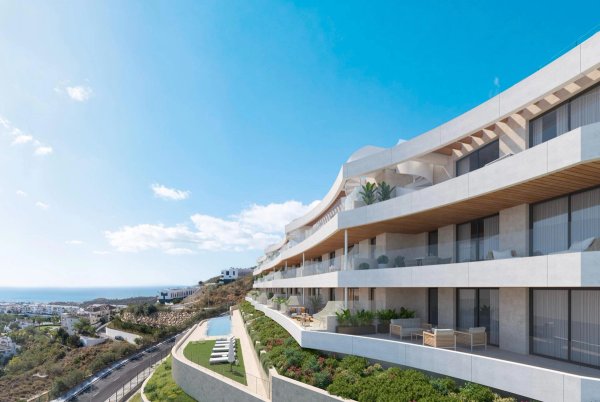 Exterior view of a modern apartment building in Rincon de la Victoria, Costa del Sol, Spain. The building has multiple floors with large terraces and a pool.