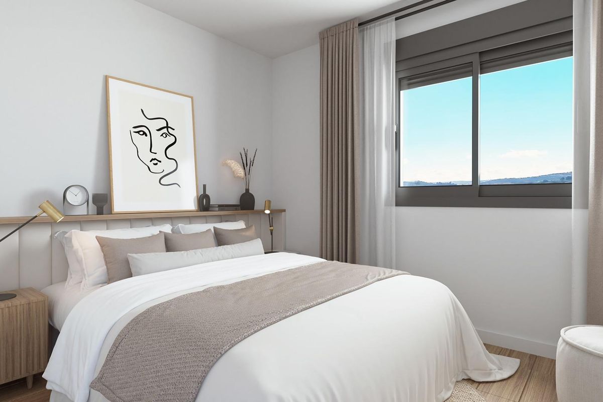 Chique gastenslaapkamer met stijlvolle decoratie en een groot raam dat een prachtig uitzicht op Estepona toont.