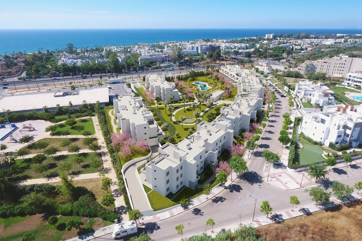 Panoramisch uitzicht op het wooncomplex in Estepona, met groene ruimtes en zwembadgebieden.
