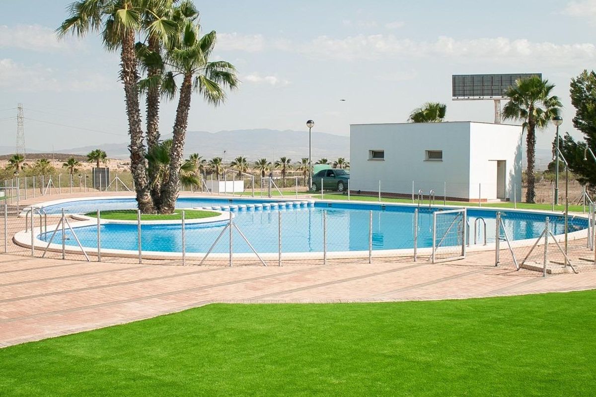 Zonovergoten zwembadgebied met palmbomen en veiligheidshekken in Fuente Álamo, ideaal voor gezin.