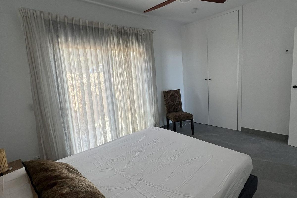 Ruime tweede slaapkamer in een townhouse in Polop, met grote ramen en minimalistische decoratie in Costa Blanca Noord.