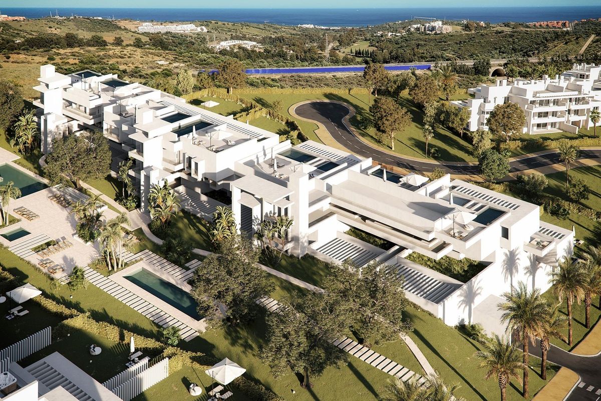 Luchtfoto van een modern appartementencomplex in Casares, Costa del Sol met weelderige tuinen en zwembaden.