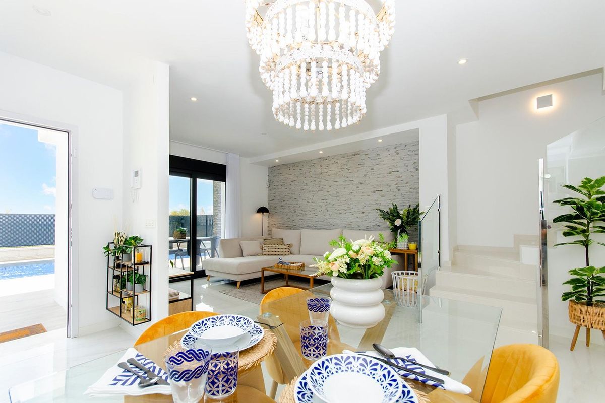Heldere woonkamer met stijlvolle inrichting en kroonluchter in een moderne 3-slaapkamer villa in Orihuela, Costa Blanca.