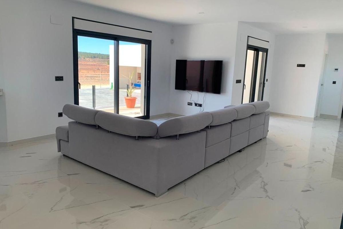Woonkamer met sofa en wand-tv, heldere ruimte in een villa met 4 slaapkamers in Pinoso, Costa Blanca.