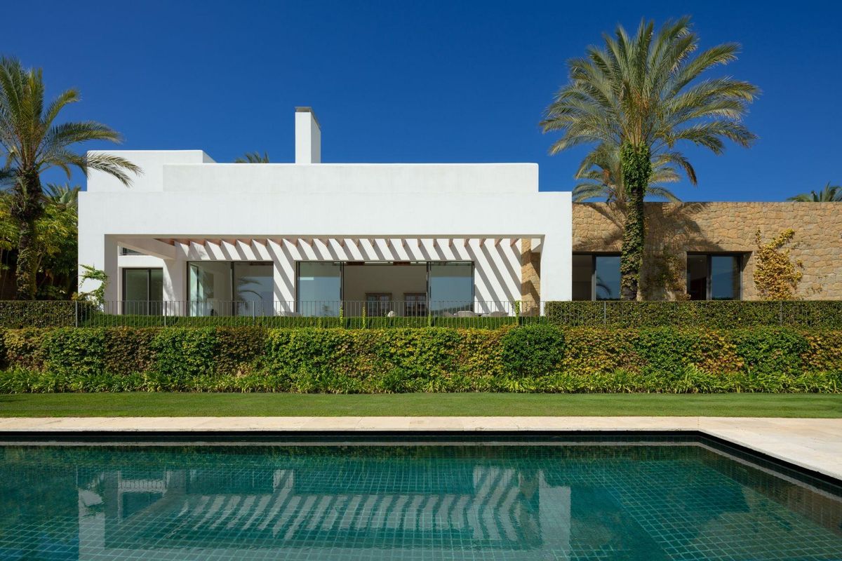 Elegante witte villa met palmbomen en een zwembad in de tuin, gelegen in Casares, Costa del Sol, Spanje.