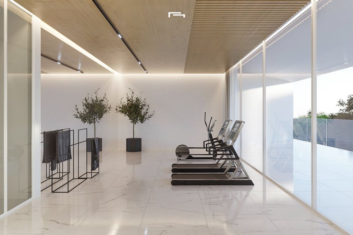 Moderne gym in een villa in Moraira, met glazen wanden en stijlvolle fitnessapparatuur voor luxe trainingen.