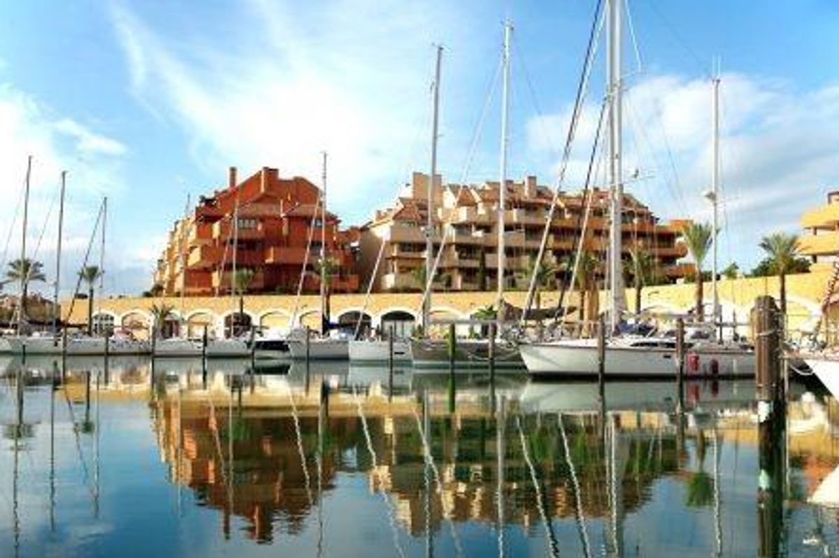 Zeilboten aangemeerd in jachthaven met moderne appartementen in Sotogrande