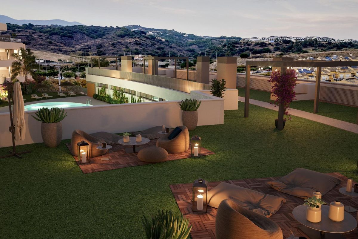 Avondzicht op het tuingebied met comfortabele zitplaatsen bij het zwembad in Estepona, Costa del Sol.