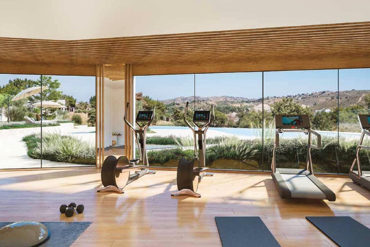Goed uitgeruste fitnessruimte met grote ramen en uitzicht op de tuin in Mijas, Costa del Sol.