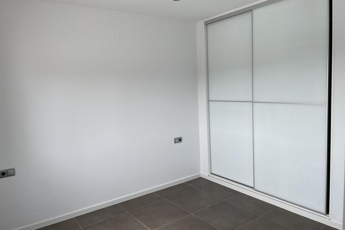 Minimalistische slaapkamer met ingebouwde kast, benadrukt ruimte in een 4-slaapkamer villa in Moraira Teulada.