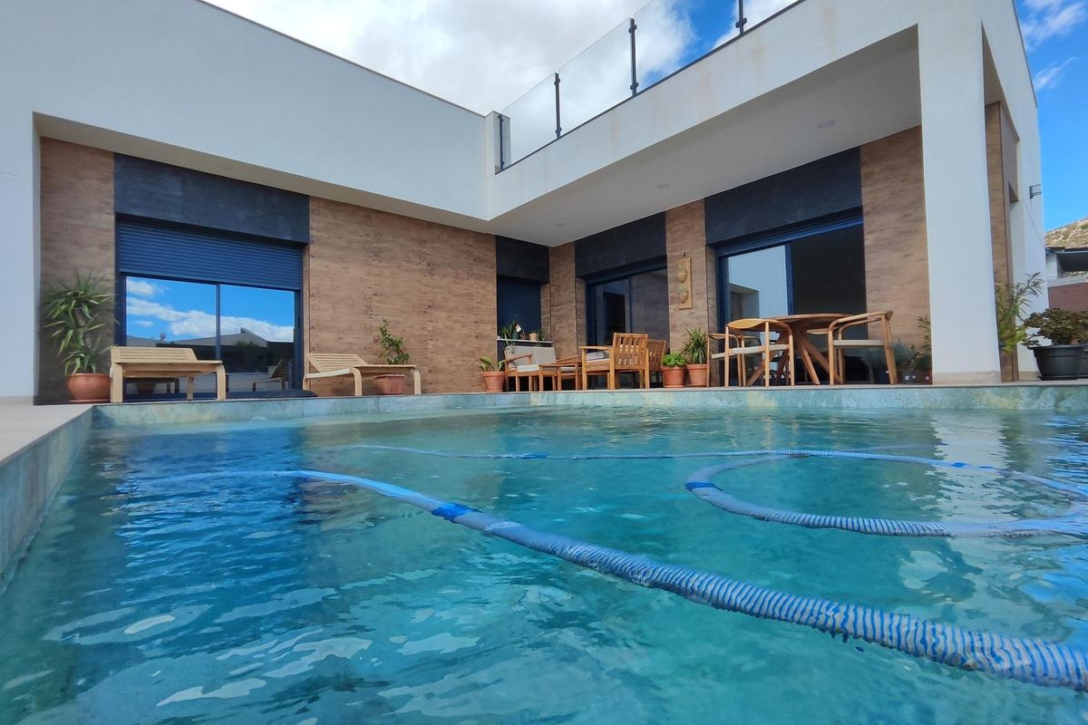 View of the villa's pool and outdoor seating area from the water, located in Pinoso, Costa Blanca.