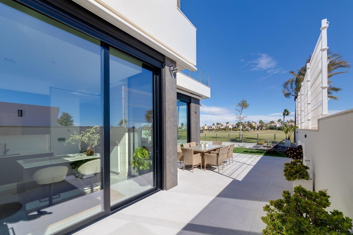 Buiten eetruimte met uitzicht op het zwembad en de tuin in een 3-slaapkamer villa in Pilar de La Horadada.