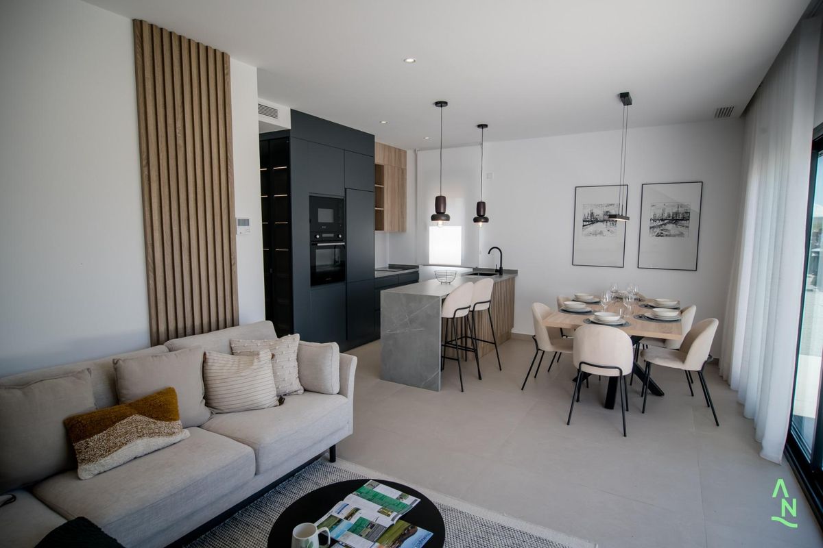 Ruime woonkamer met een bank en eetopstelling in een modern 2-slaapkamer appartement in Alhama de Murcia.