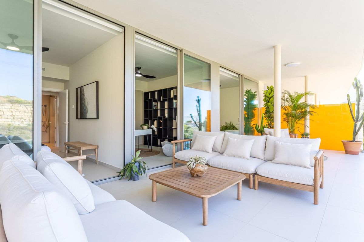 Uitnodigend terras met zitgelegenheid en uitzicht op de woonruimte van het appartement in Fuengirola.