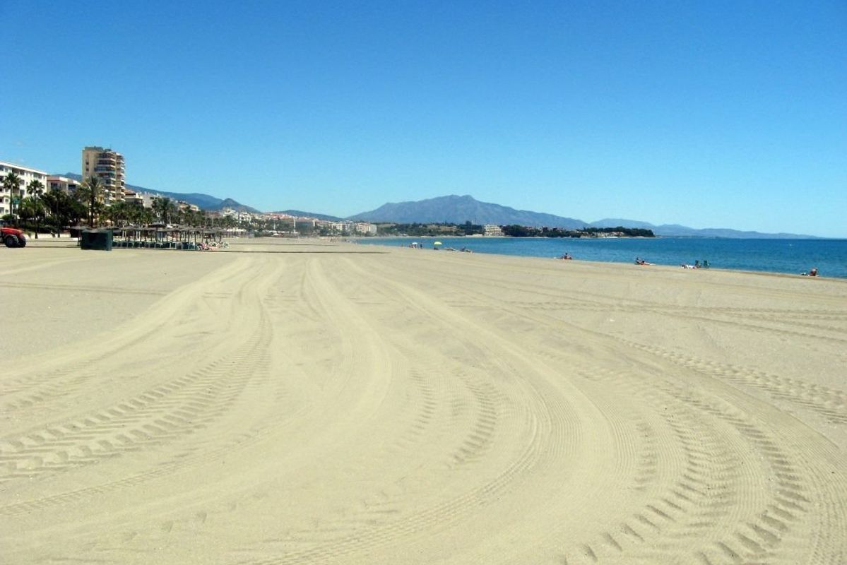 Rustig zandstrand in Estepona met een prachtig uitzicht op de kust en nabijgelegen bergen.