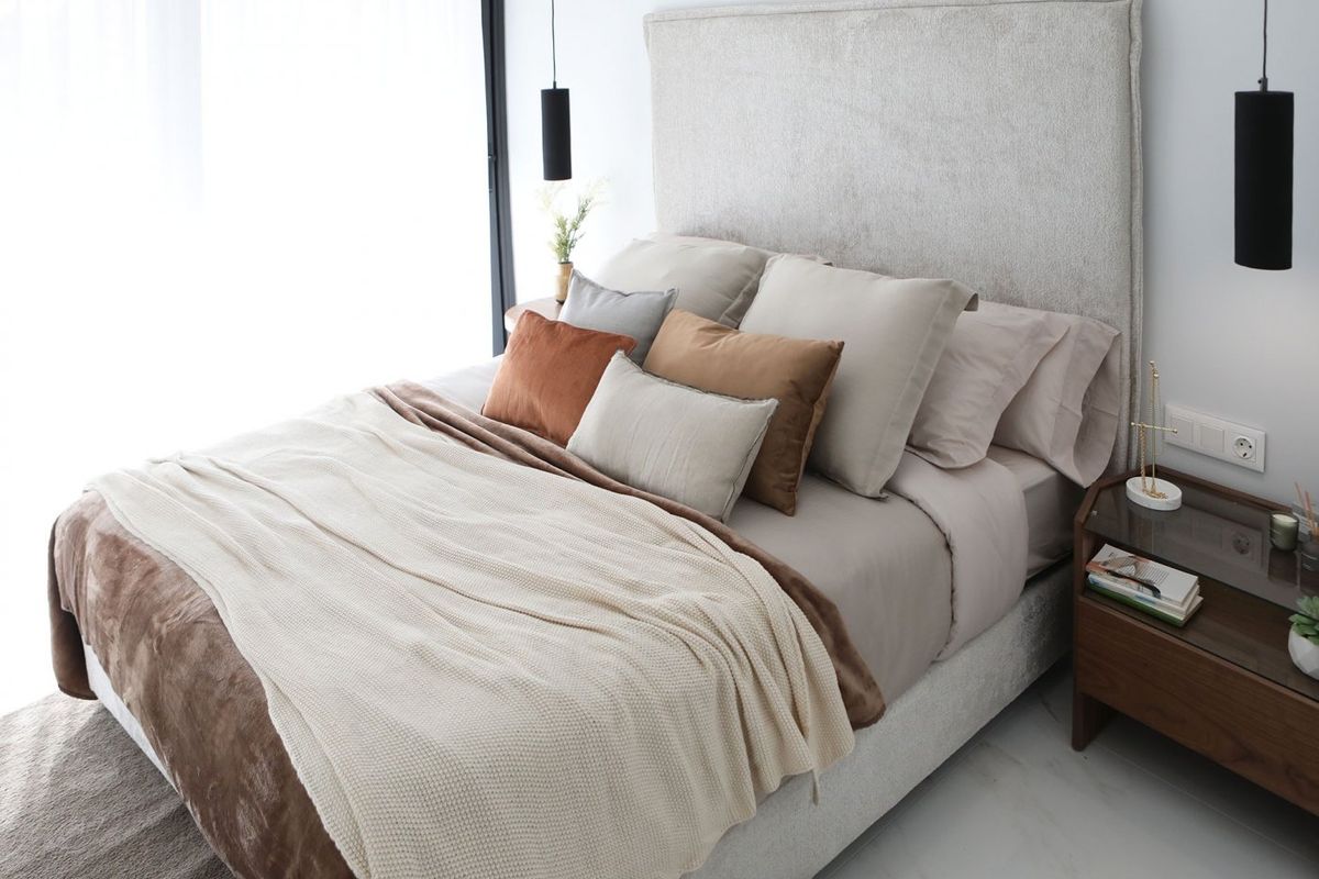 Chique slaapkamer met een rijke kleurenpalet en luxe beddengoed in een appartement in Benidorm met 3 slaapkamers.