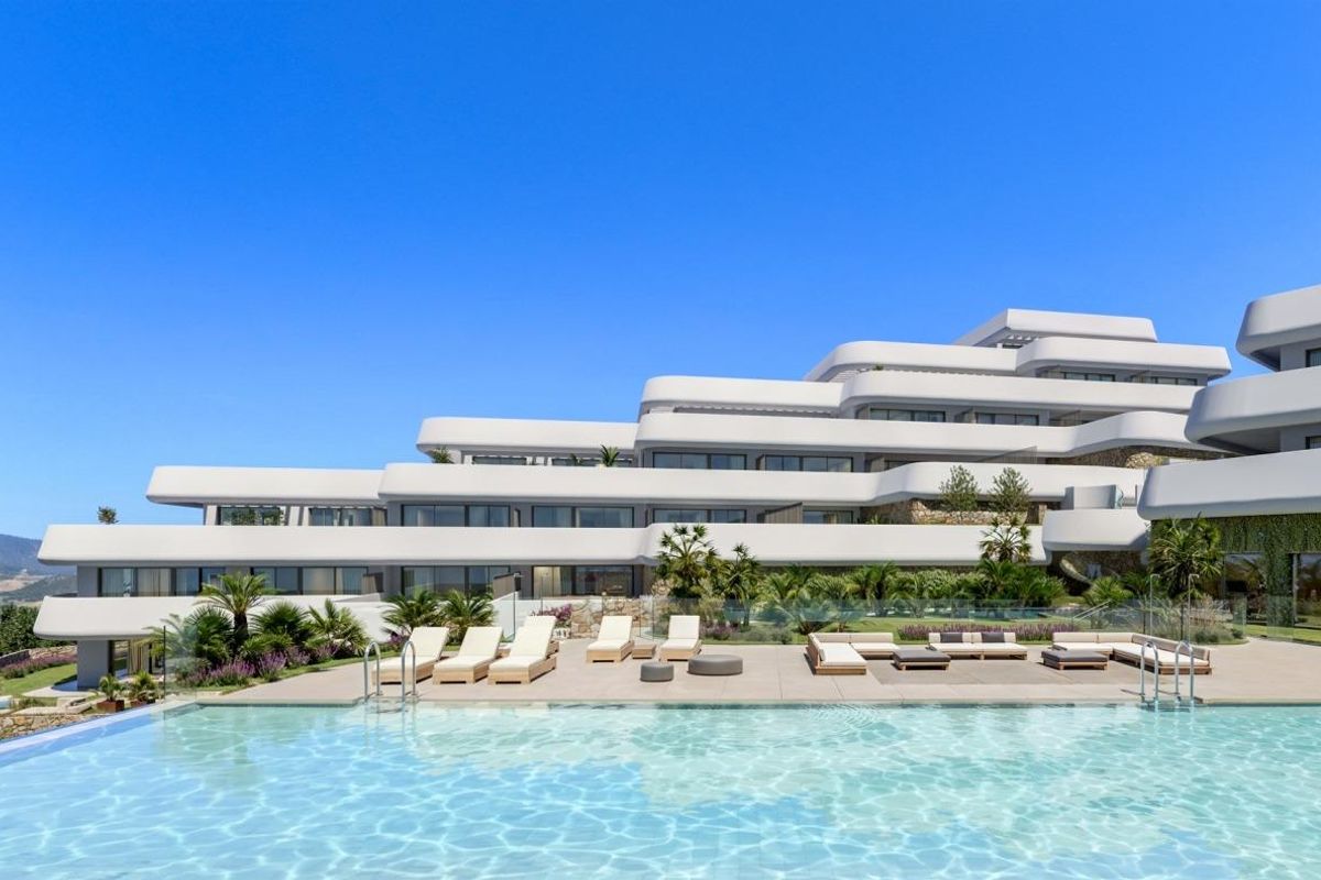 Zijaanzicht van het zwembad van een modern appartementcomplex in Casares, Costa del Sol met groene omgeving.