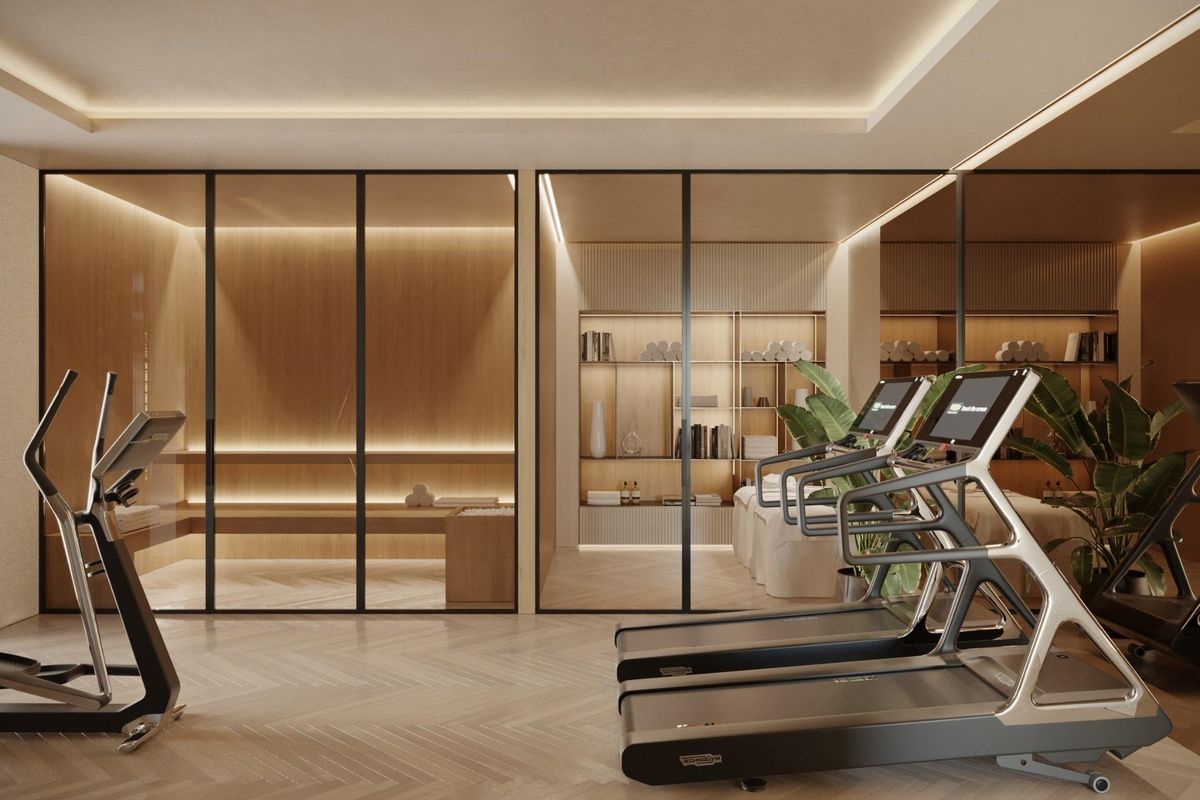 Goed uitgeruste gym met moderne fitnessapparaten en warme verlichting in een villa in Marbella.