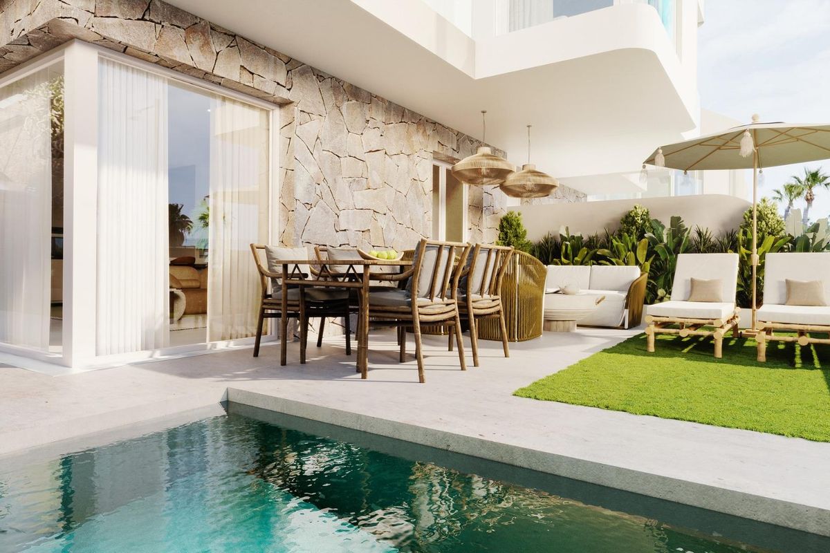 Buitenruimte van een 3-slaapkamer townhouse in Mojacar, met een zwembad, eethoek en ligstoelen op een terras.