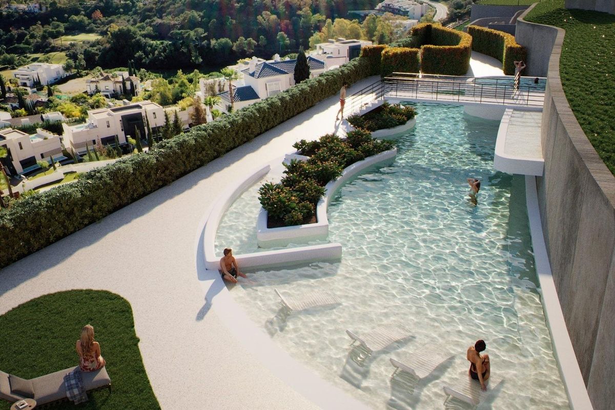 Ontspannend zwembad met ligbedden en aangelegde tuinen, met op de achtergrond de heuvels van Benahavís.