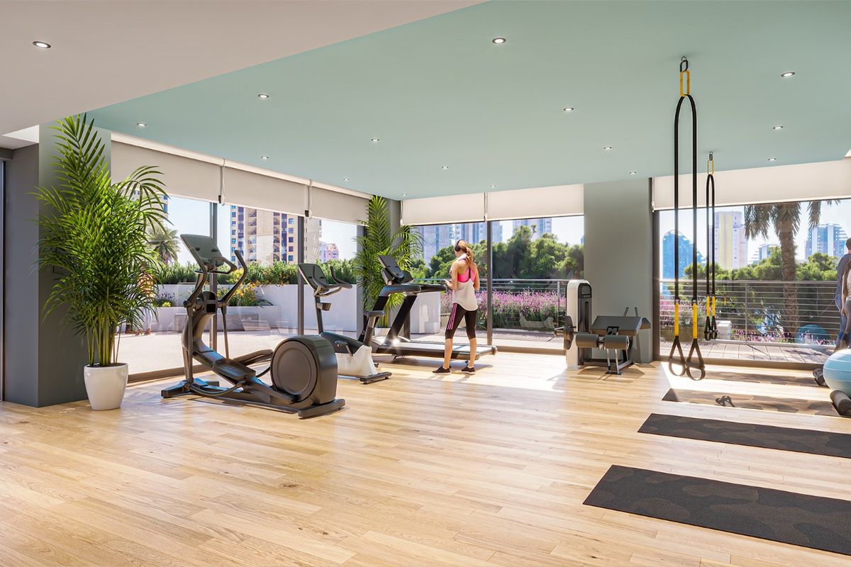 Heldere sportschool met moderne apparatuur en uitzicht op de buitenruimte in Benidorm.