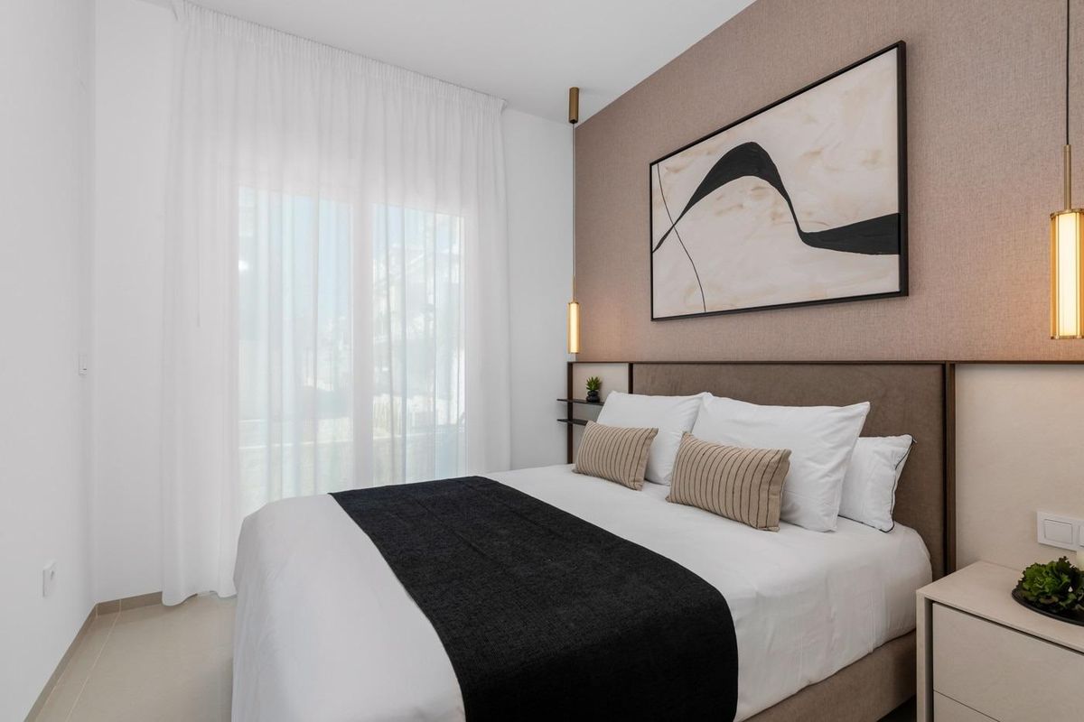 Serene slaapkamerontwerp met smaakvolle decoratie en natuurlijk licht in een bungalow gelegen in Rojales, Spanje.