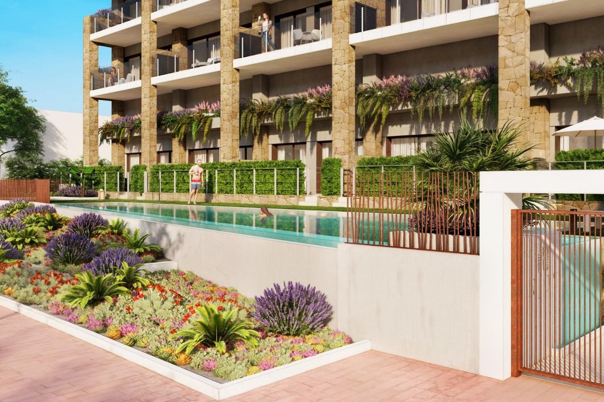 Uitzicht op het zwembad met aangelegde tuinen nabij de moderne appartementen in Villajoyosa.