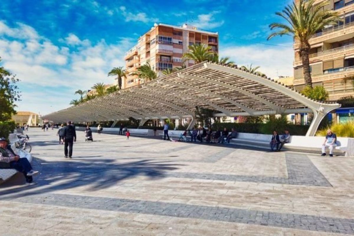 Moderne promenade in Torrevieja met overdekte zitruimtes en met palmen omzoomde paden voor voetgangers.