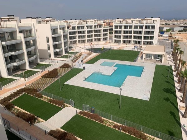 Panoramisch uitzicht op het penthousecomplex in Orihuela Costa met een stijlvolle zwembad en groen gebied.