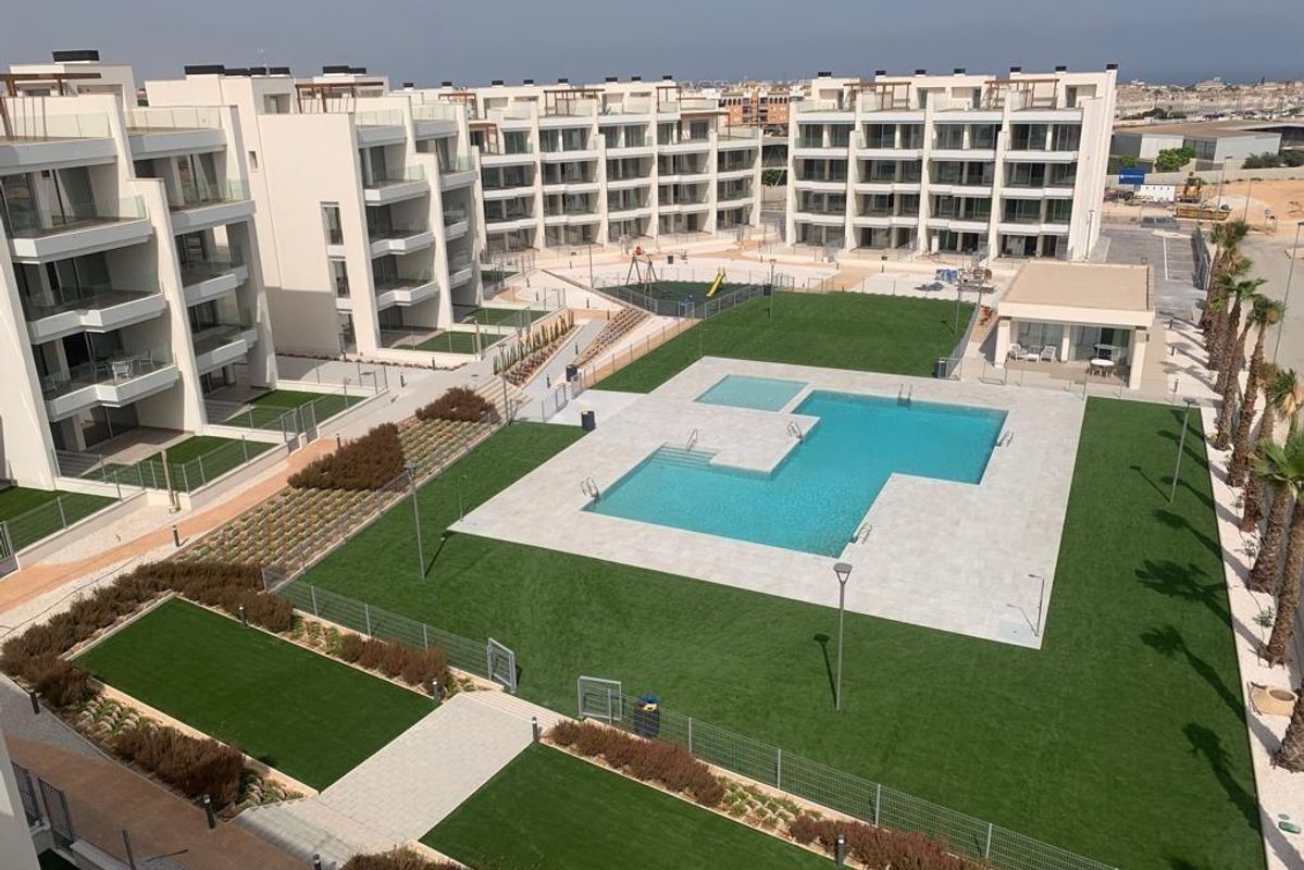 Panoramisch uitzicht op het penthousecomplex in Orihuela Costa met een stijlvolle zwembad en groen gebied.