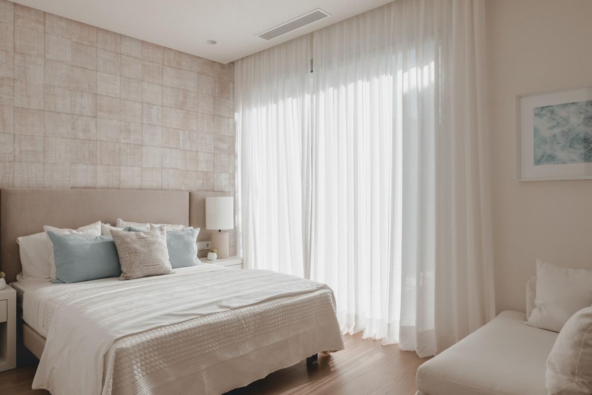 Goed verlichte slaapkamer in een appartement in Benahavís, met een charmante sfeer, zachte gordijnen en gezellige decoratie.