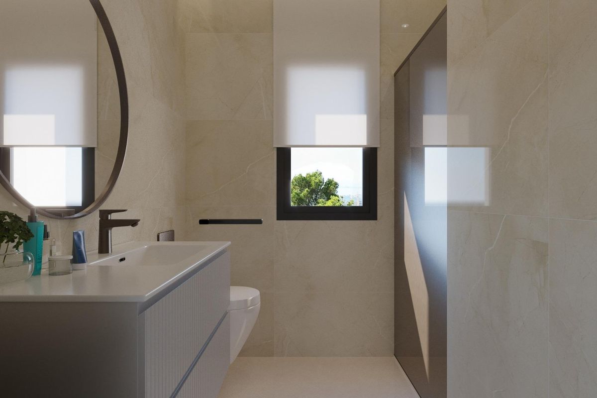 Stijlvolle badkamer met elegante afwerkingen en een grote spiegel in een luxe villa in Finestrat, Spanje.