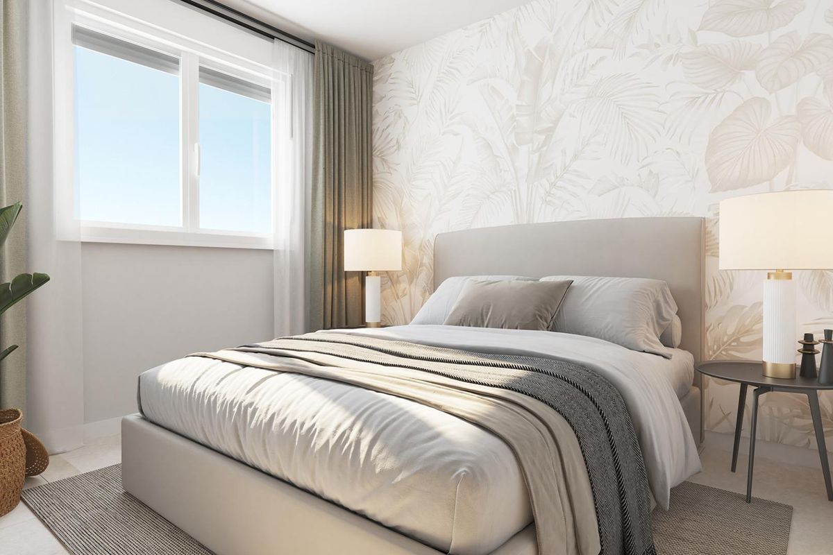 Uitnodigende slaapkamer met serene inrichting en grote ramen in een begane grond appartement in Estepona.