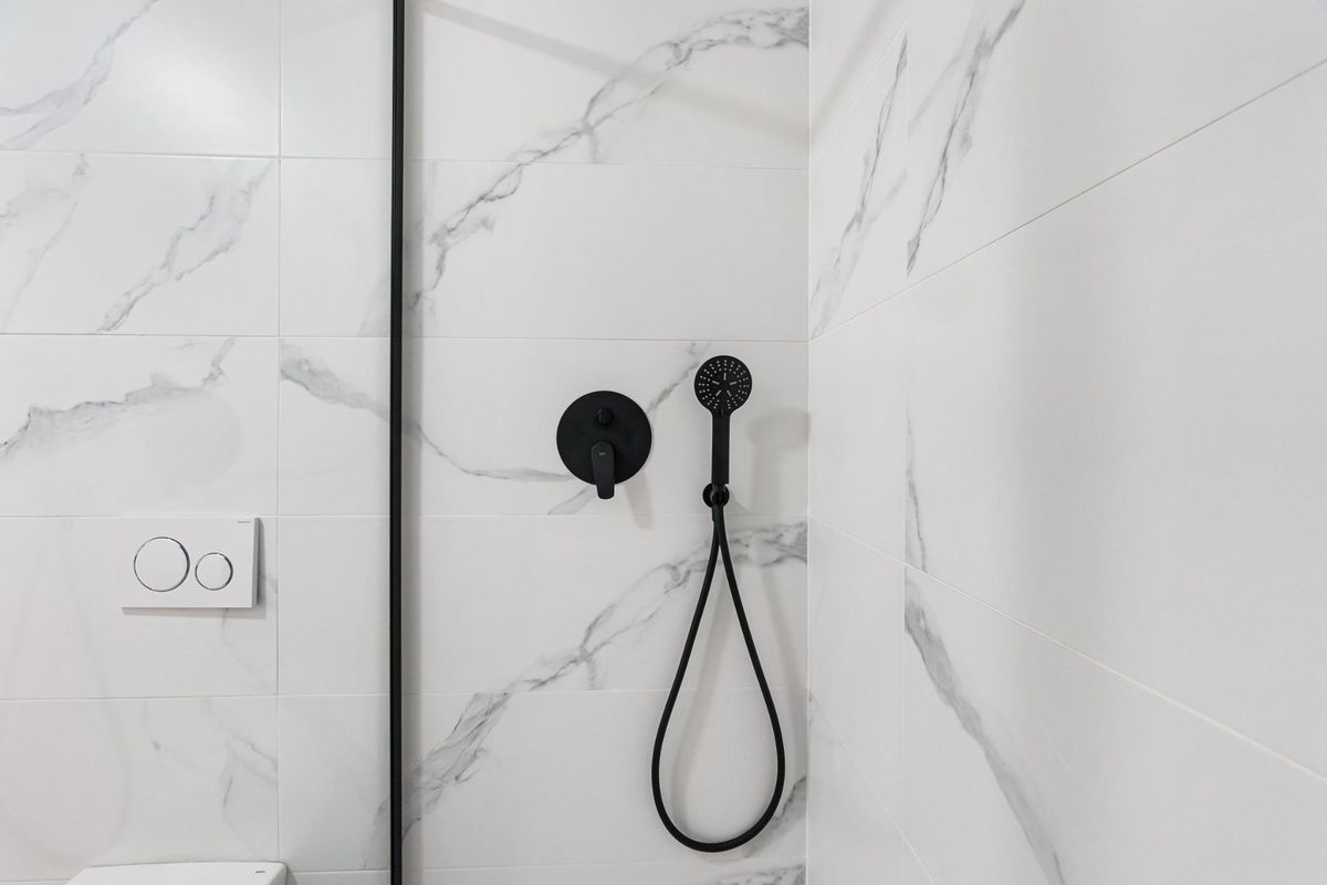 Close-up van douchearmaturen in een moderne badkamer van een appartement in San Javier.