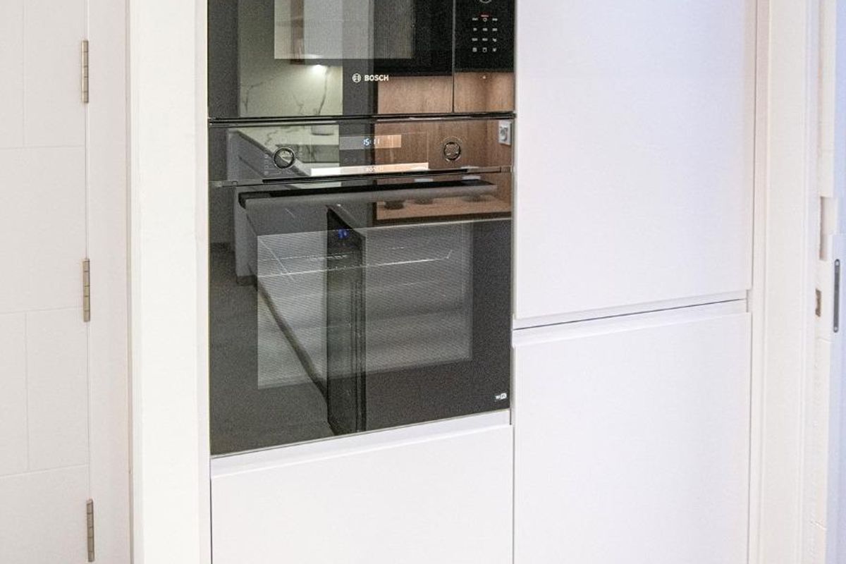 Strakke keukenwand met geïntegreerde apparaten in een modern appartement in San Pedro del Pinatar.