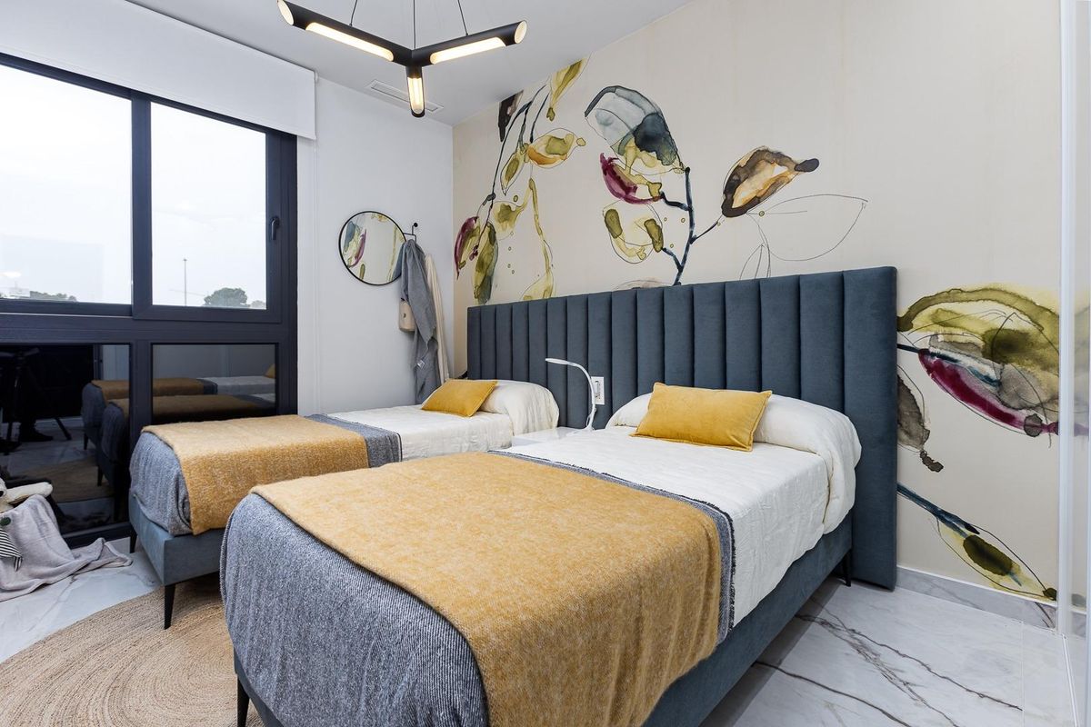 Heldere tweepersoons slaapkamer ontworpen met kleurrijke accenten, ideaal voor een 2-slaapkamer appartement in Orihuela Costa.