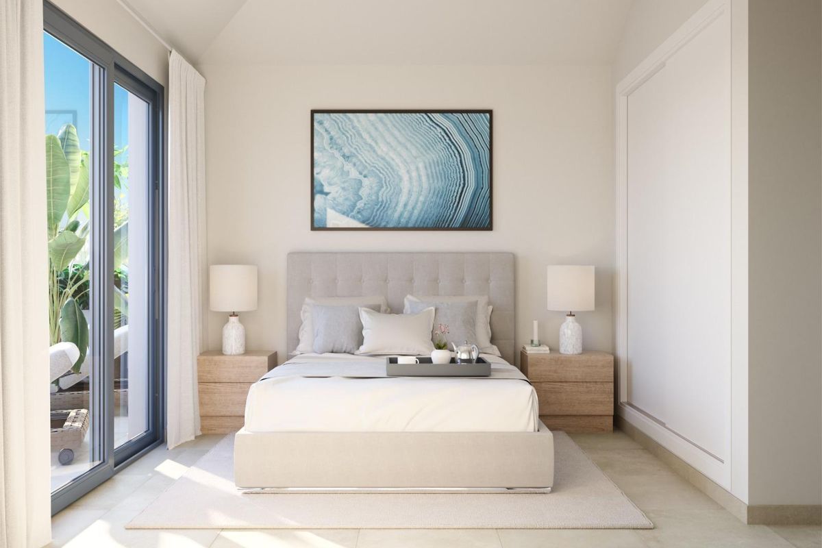 Elegante master slaapkamer in het 3-slaapkamer penthouse, met een luxe bed en uitzicht op de tuin in Fuengirola.