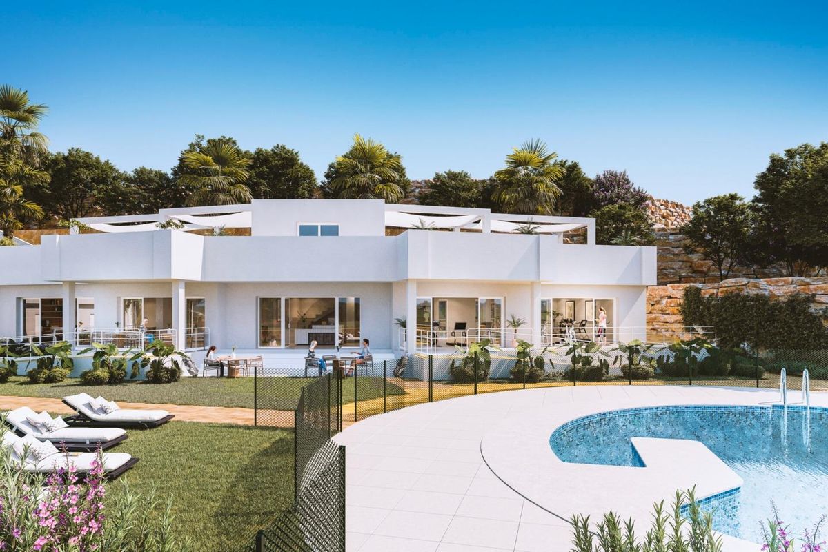 Buitenkant van het gelijkvloerse appartementencomplex in Estepona met zwembad en tuin.
