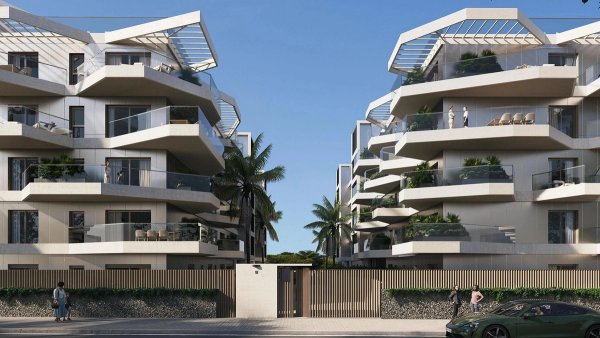 Vooraanzicht van moderne appartementgebouwen in Mijas, Costa del Sol, met palmbomen en balkons.
