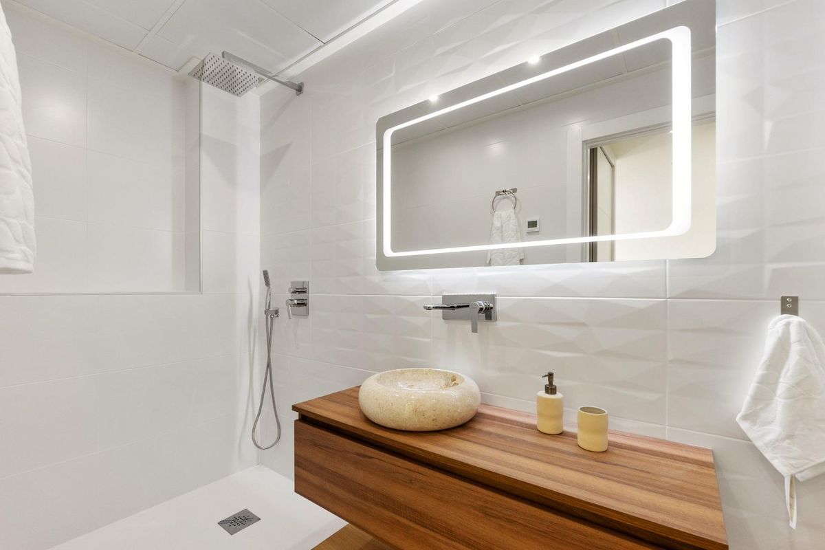 Elegante badkamer met moderne armaturen en houten accenten in een Rojales villa, perfect ontworpen.