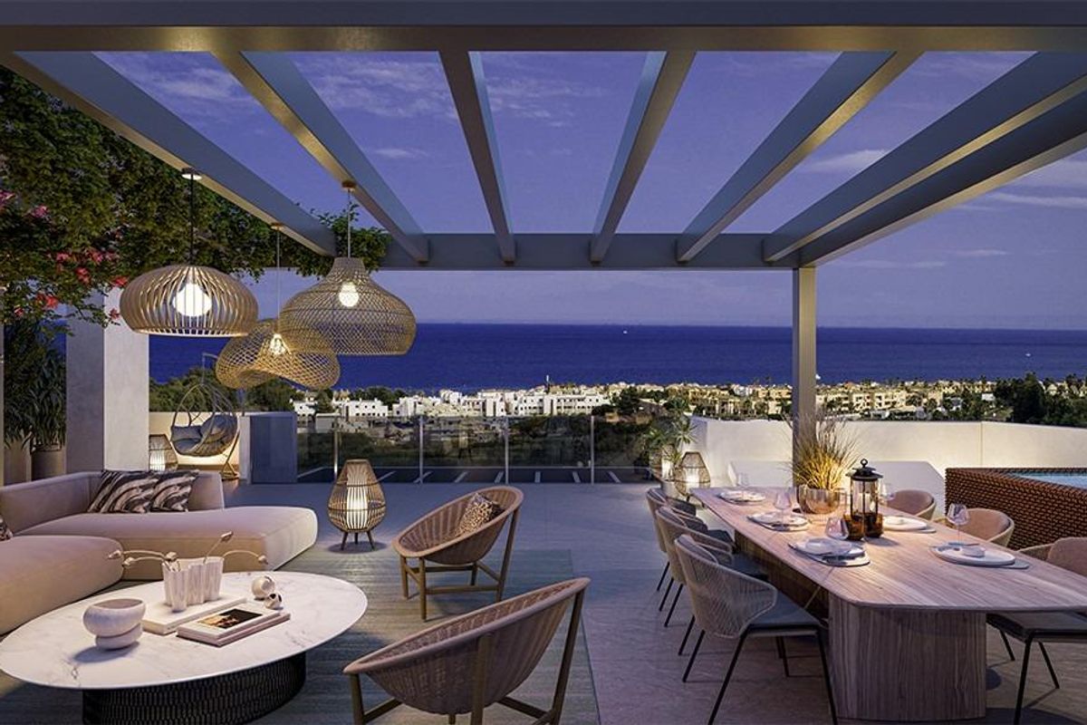 Avond terraszicht met eetruimte en mooie verlichting, met uitzicht op de kust van Casares, Costa del Sol.