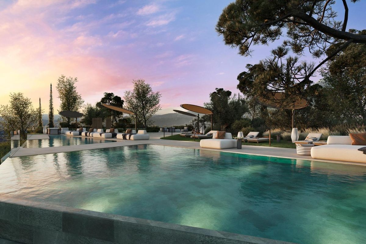 Aantrekkelijk zwembadgebied bij zonsondergang in Fuengirola, omringd door loungebedden en elegante beplanting.