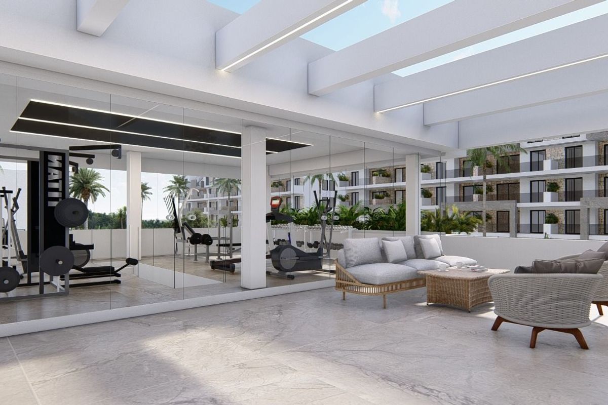 Stijlvol loungegebied met uitzicht op het zwembad in een fitnesscentrum van een appartement in Guardamar del Segura.