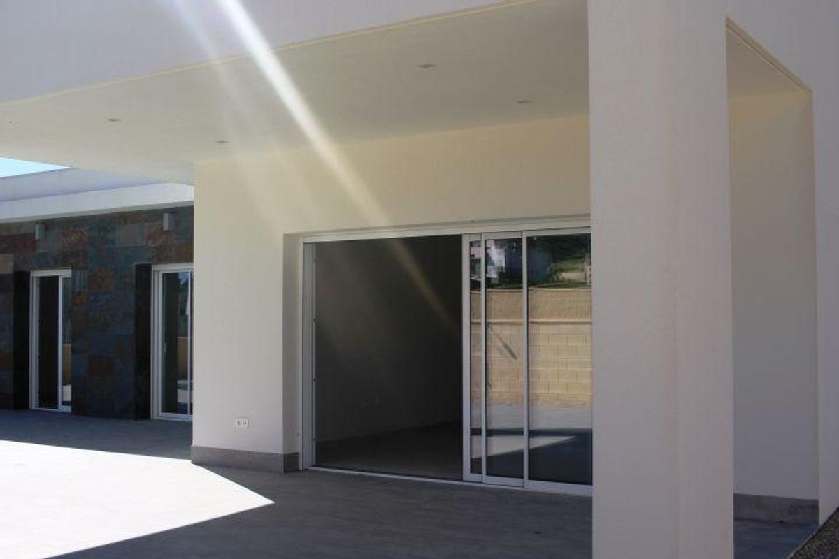 Uitzicht op de ingang en buitenkant van de moderne villa, ontworpen voor comfort en stijl in La Romana, Costa Blanca.