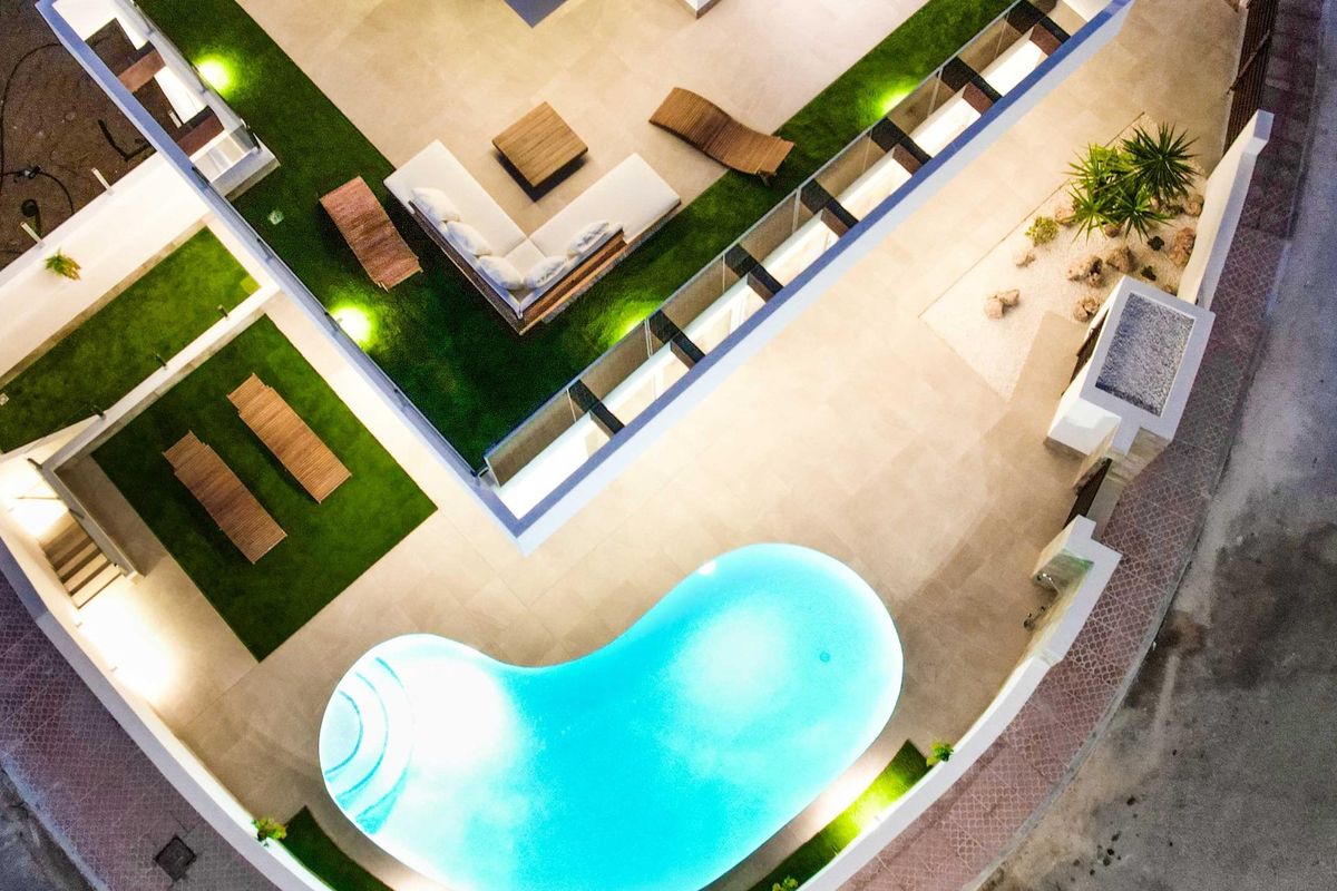 Bovenaanzicht van een stijlvolle zwembad en terrasruimte van een villa in Ciudad Quesada, omgeven door groen.