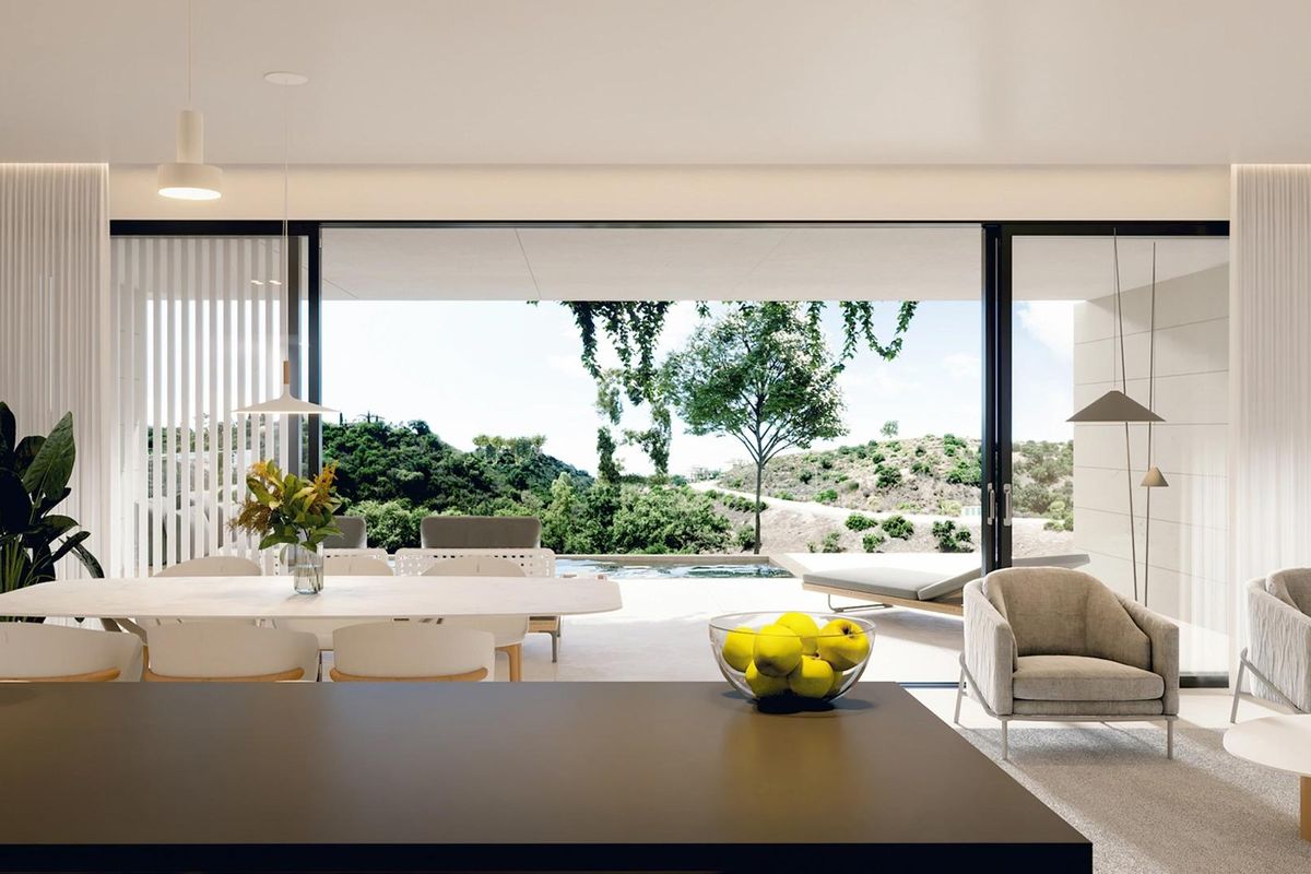 Heldere woonkamer met eetruimte en uitzicht op de tuin in een modern appartement in Marbella.